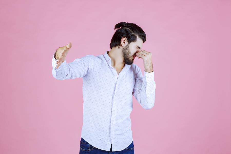 un homme se pinçant le nez